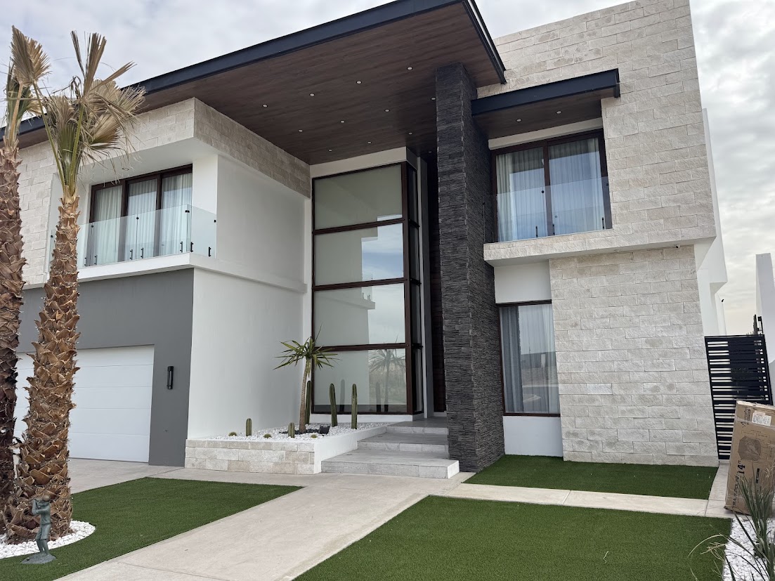 Vivienda con ventanales y puerta de entrada acristalada